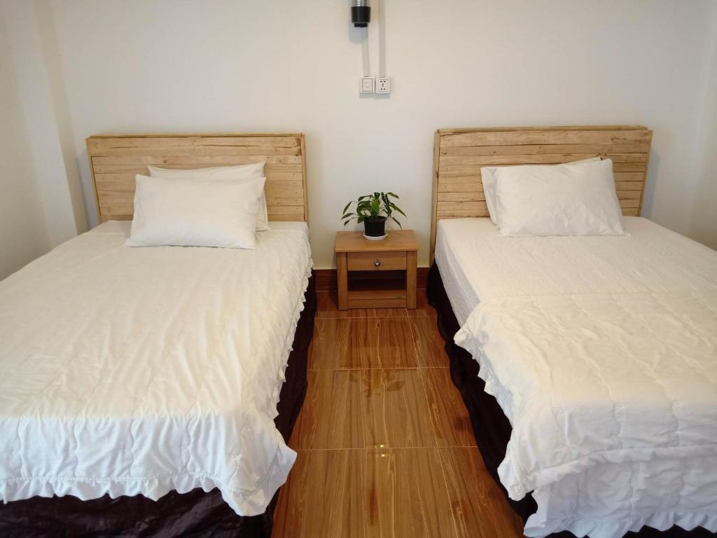 dos camas sentadas una al lado de la otra en una habitación en KOL House, en Phnom Penh