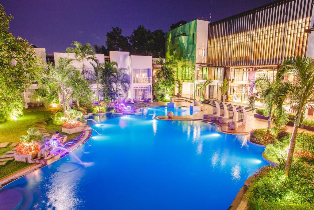 a resort pool with blue water at night at Aziza Paradise Hotel in Puerto Princesa City