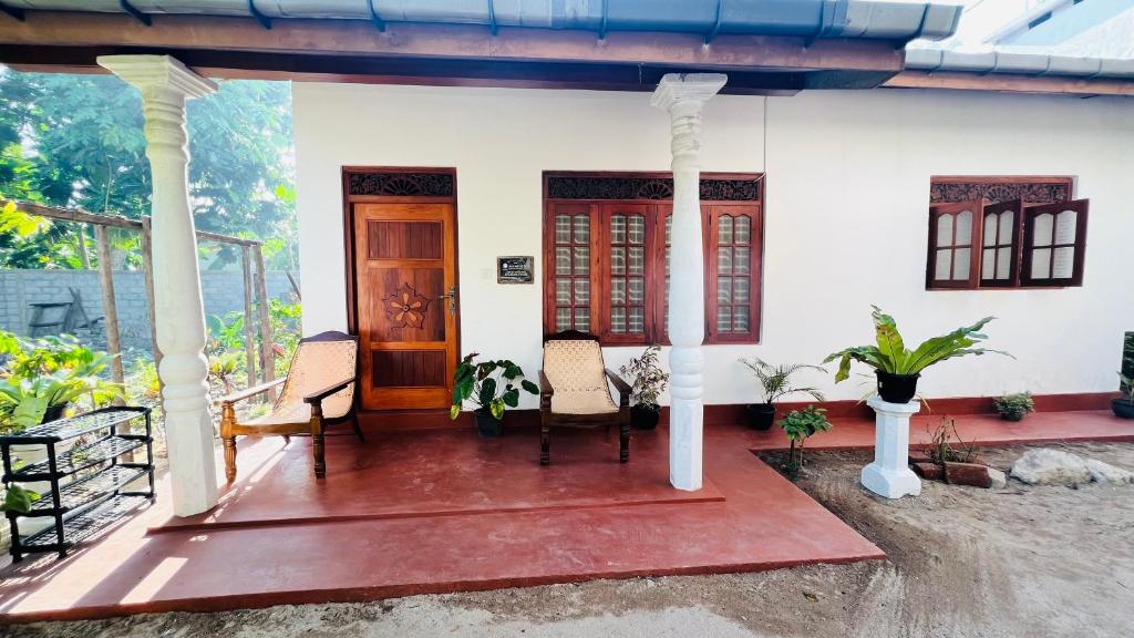 un portico di una casa con sedie e porta di Allan Villa a Midigama East