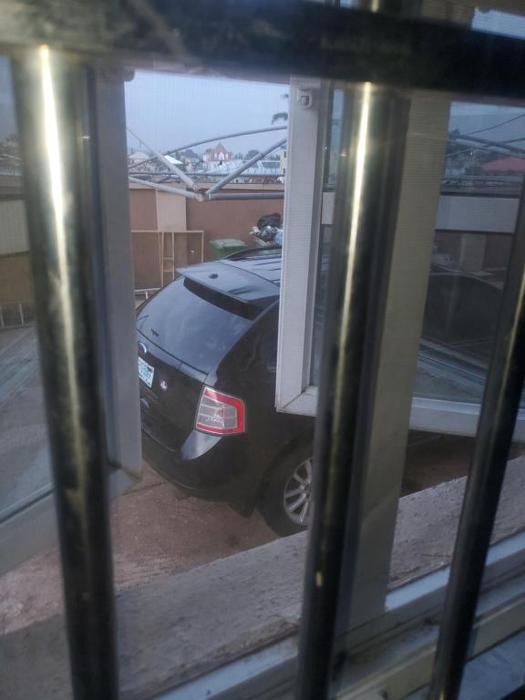 a car parked in a parking lot through a window at Miraph APt. with Starlink wifi in Abuja