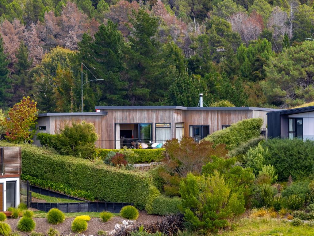 a house with a green roof at Number One Bach - Kaiteriteri Holiday Home in Kaiteriteri