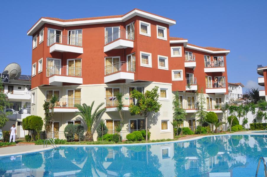 an apartment building with a pool in front of it at Hanay Suit Otel in Side