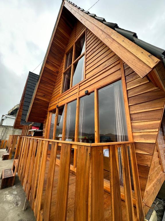 ein Holzhaus mit einem großen Fenster in der Unterkunft CALLA HOMESTAY DIENG in Diyeng
