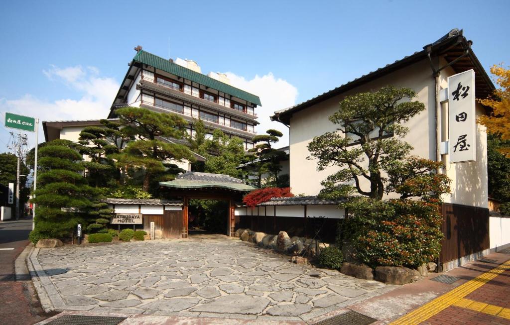 a building with a stone sidewalk in front of a building at Matsudaya Hotel in Yamaguchi