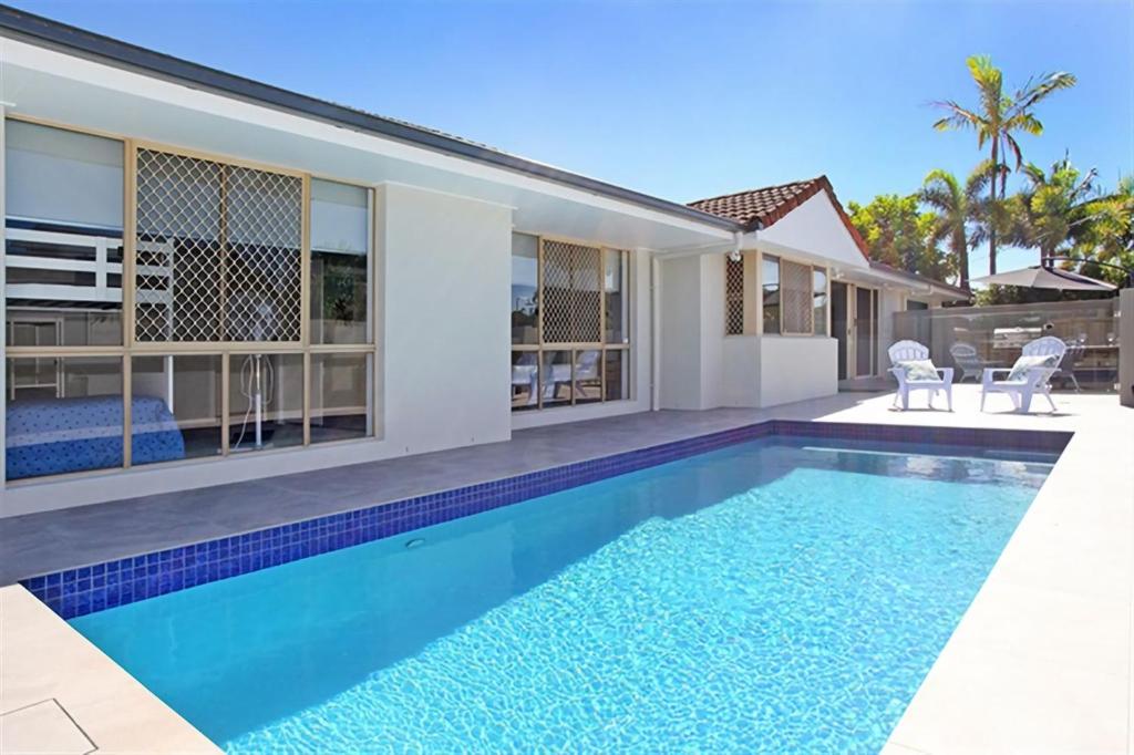a swimming pool in the backyard of a house at Beautiful Beach House in the Heart of Town in Coolum Beach