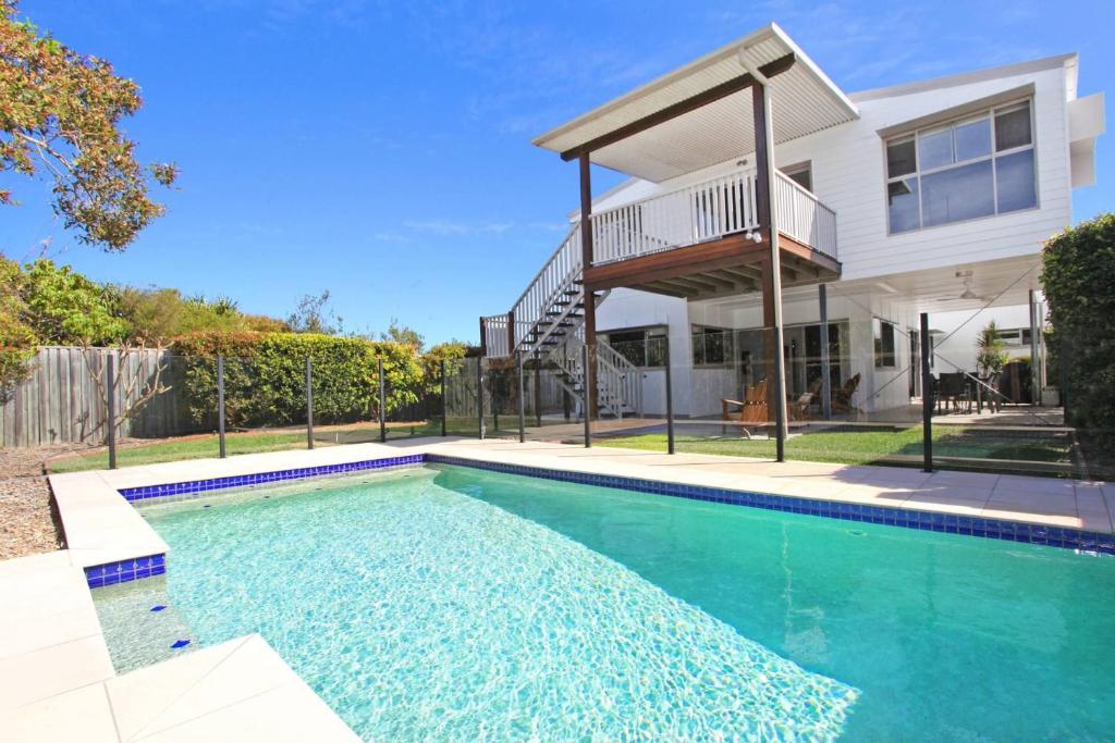 a swimming pool in front of a house at 15 Wave Crescent in Marcoola