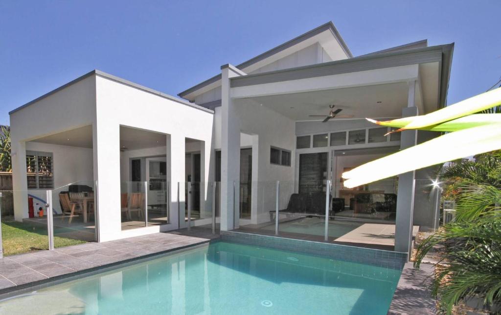 a villa with a swimming pool and a house at 48 Boardrider Crescent in Marcoola