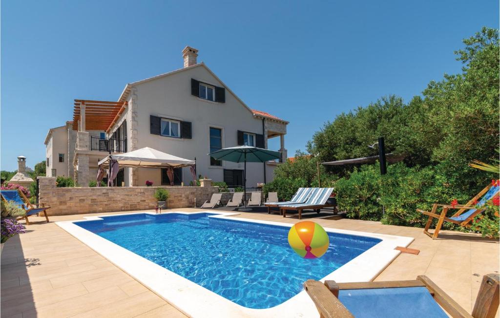 una piscina con pallone da spiaggia di fronte a una casa di 6 Bedroom Stunning Home In Lumbarda a Lumbarda (Lombarda)