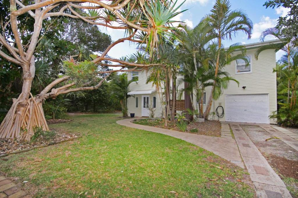 a house with palm trees and a driveway at 25 Goongilla Street in Yaroomba