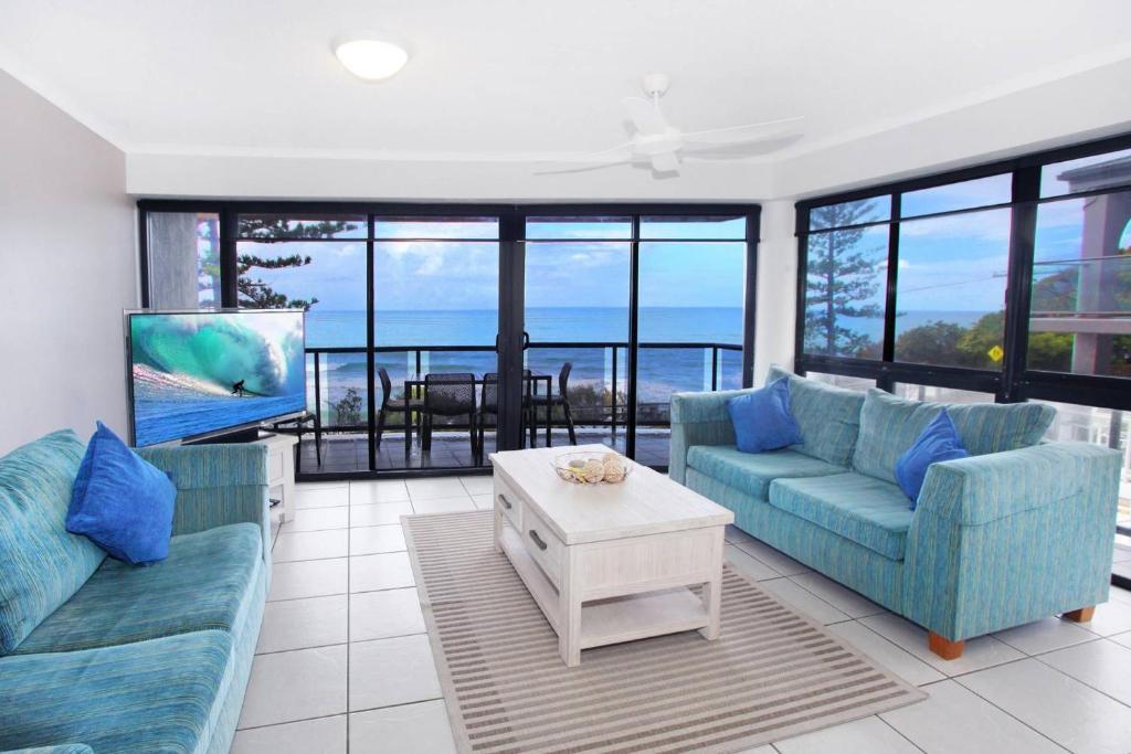 ein Wohnzimmer mit blauen Sofas und Meerblick in der Unterkunft Unit 5 Phoenix in Coolum Beach