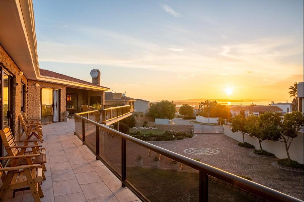 a balcony of a house with the sunset in the background at Glenfinnan Guest House in Langebaan