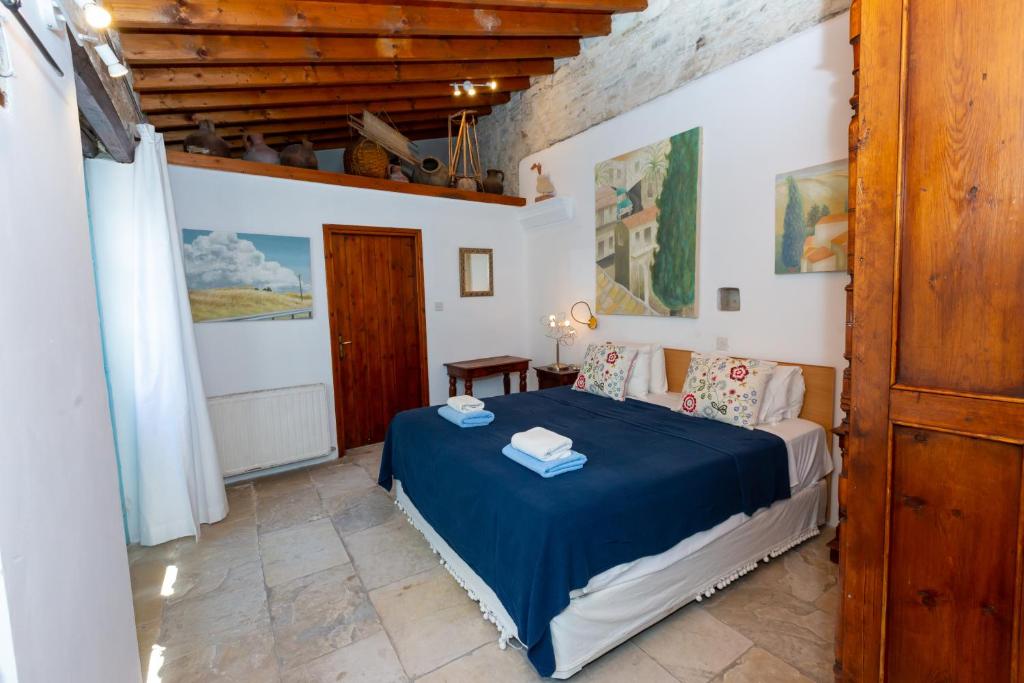 ein Schlafzimmer mit einem blauen Bett in einem Zimmer in der Unterkunft Cyprus Villages Kalavasos in Kalavasos