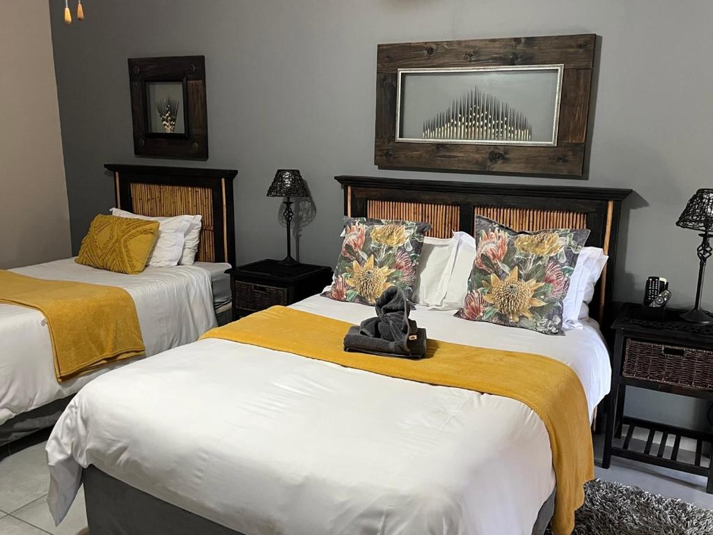 a bedroom with two beds with yellow sheets at Sanyati Guesthouse in Kathu