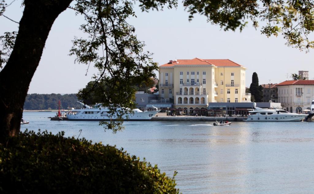a group of boats on a river with buildings at BO Hotel Palazzo in Poreč