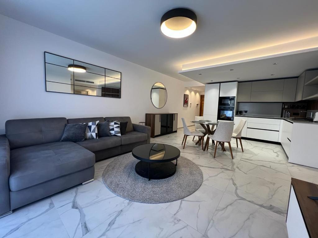een woonkamer met een bank en een tafel bij Skylark 2 Apartment with Terrace in Is-Swieqi