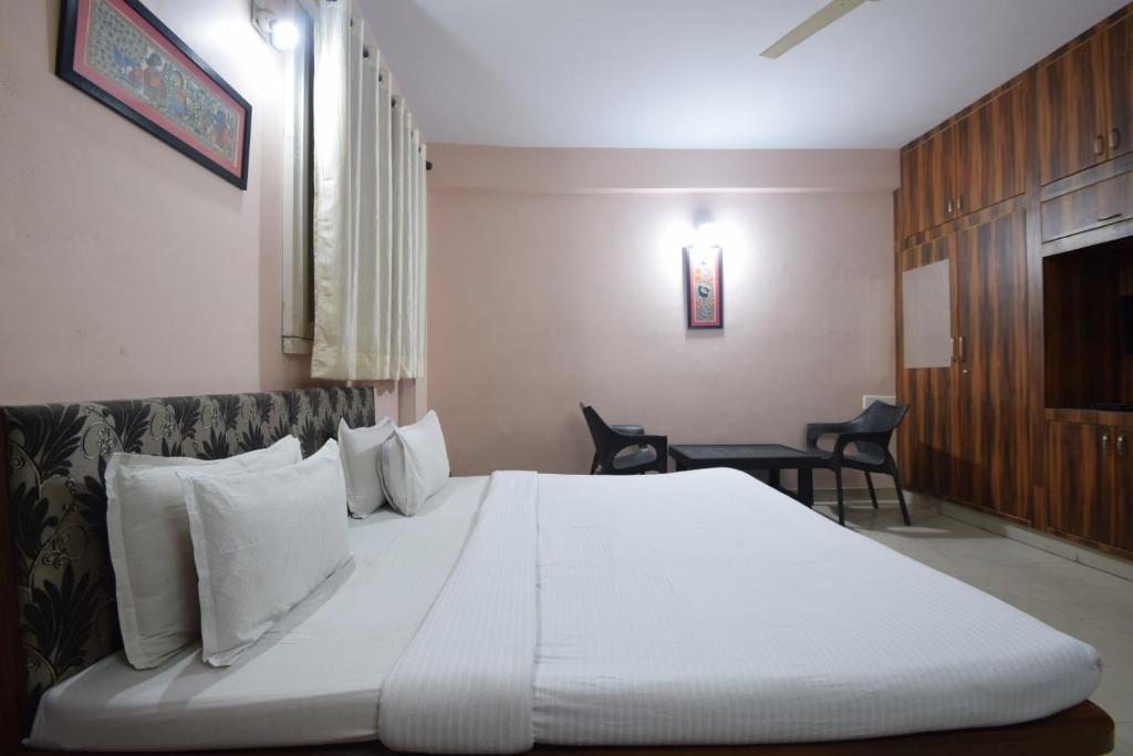 a bedroom with a large white bed and a table at Shreenath JI inn in Udaipur