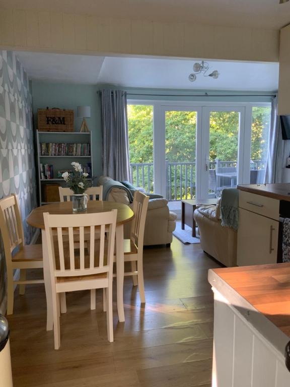 cocina y sala de estar con mesa y sillas en CRIB GOCH HOLIDAY CABIN SNOWDONIA en Caernarfon
