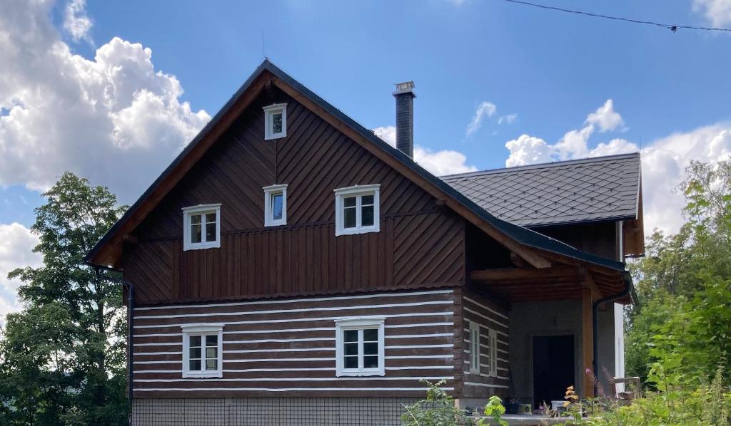 Chalupa Střelenka في يانوف نادنيسو: منزل خشبي كبير مع سقف مقامر