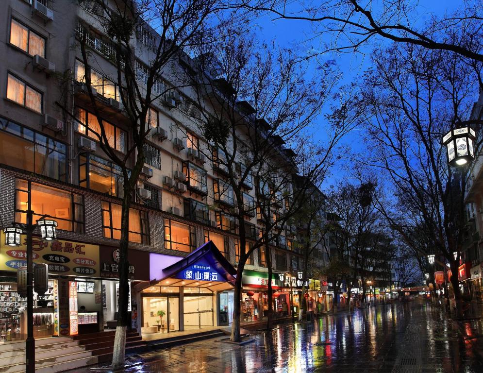 桂林象山璞云酒店(桂林两江四湖东西巷店)的夜间与建筑物的一条湿城市街道