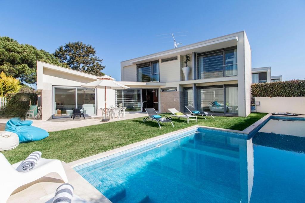 una casa con piscina frente a una casa en Villa do Casalinho, en Sesimbra