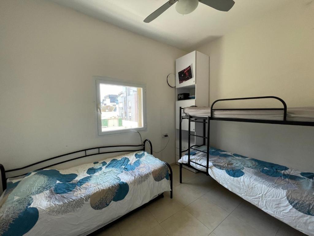 1 dormitorio con 2 literas y ventana en Magnifique Penthouse vue mer, en Tel Aviv