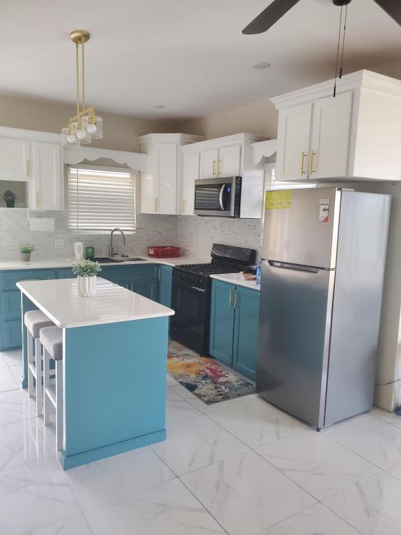 a kitchen with blue cabinets and a stainless steel refrigerator at Level27 Pent 