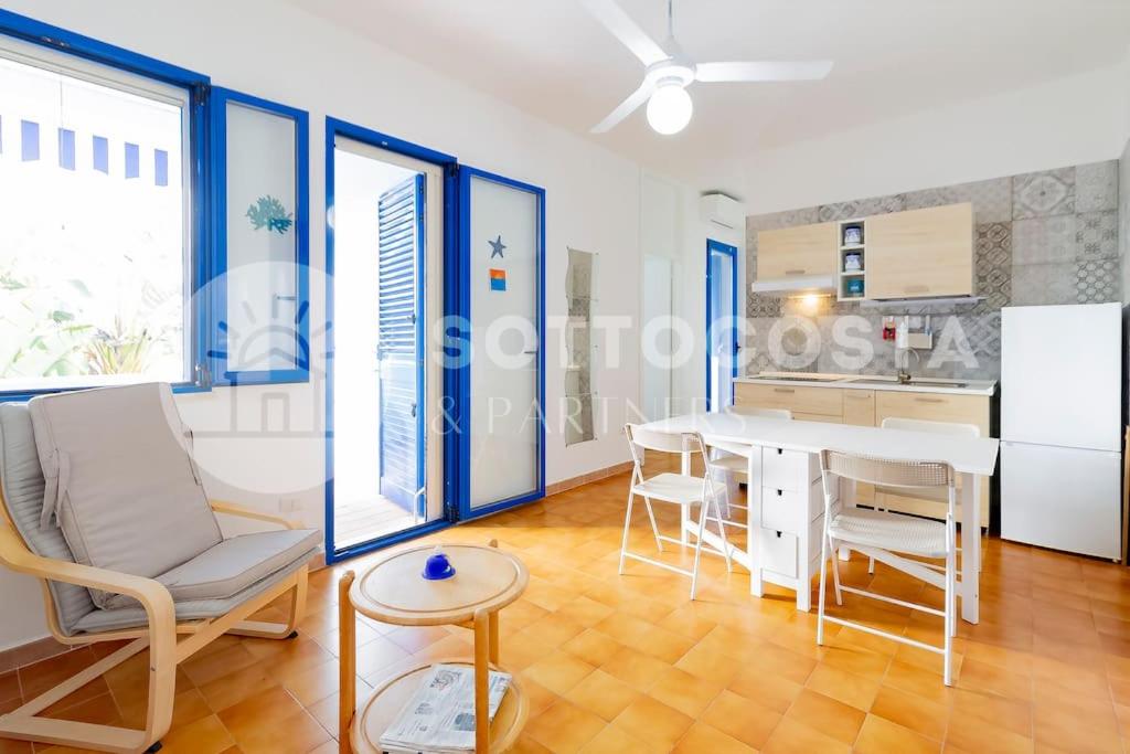 a living room with a table and chairs and a kitchen at Heavenly flat- Torre dell'Orso in Torre dell'Orso