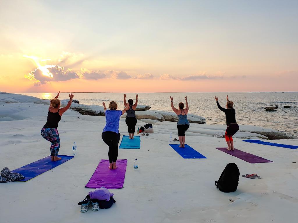 a group of people doing yoga on the beach at Cyprus Villages Hotel & Restaurant - Central Location - Bed & Breakfast - With Access To Pool And Stunning Views in Tochni