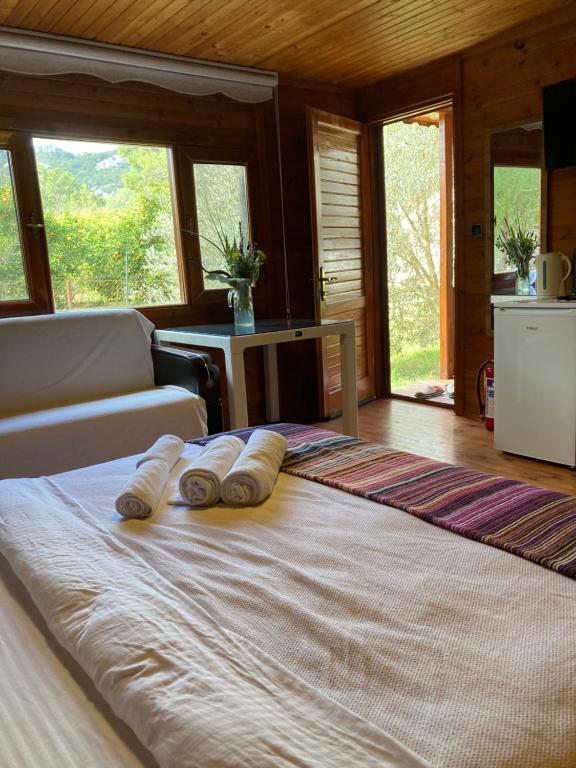 een slaapkamer met een groot bed met drie kussens erop bij şeker bungalov in Cıralı