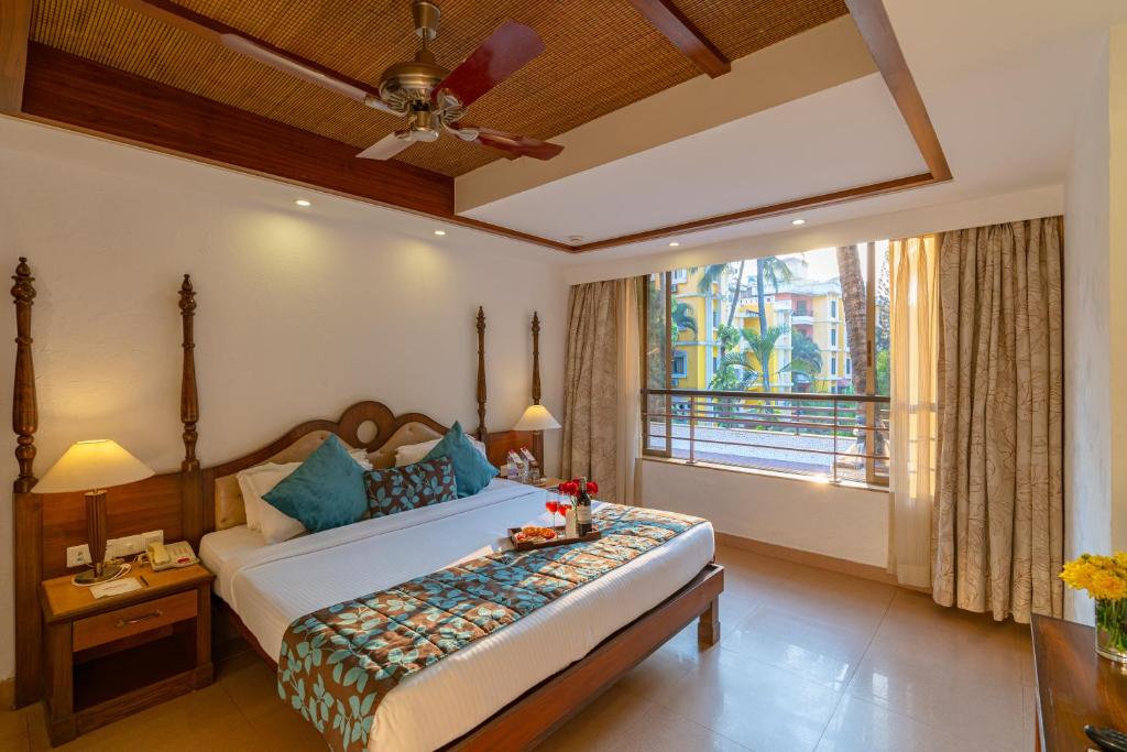 a bedroom with a bed and a large window at Adamo The Bellus in Calangute