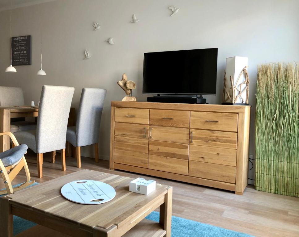 - un salon avec une télévision sur une commode en bois dans l'établissement Lindenpalais Wohnung 24, à Heiligendamm