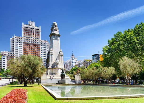 a statue in a park in a city with buildings at Punta Me Beautiful Apartment in Plaza España in Madrid