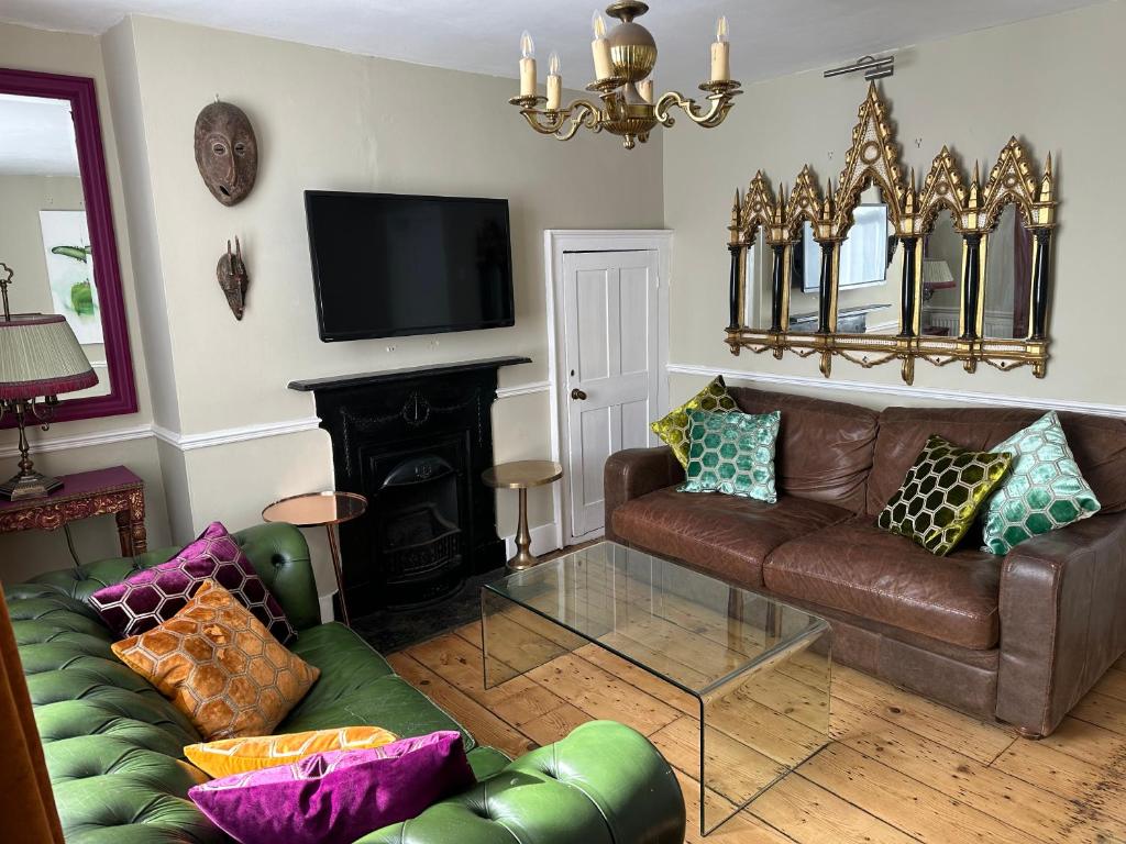 sala de estar con sofá de cuero y chimenea en The Artist House en Brighton & Hove