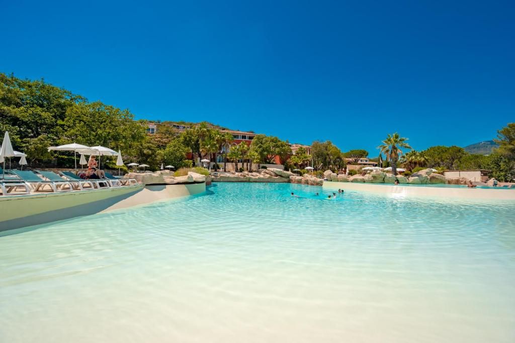 a swimming pool with people in the water at Résidence Pierre & Vacances Les Restanques du Golfe de Saint-Tropez in Grimaud