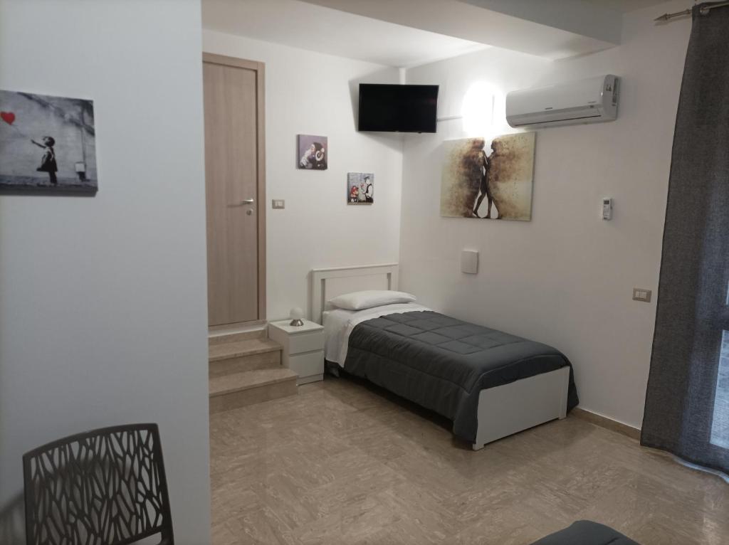 una camera con letto e TV a parete di Affittacamere Casa Quisquina a Santo Stefano Quisquina