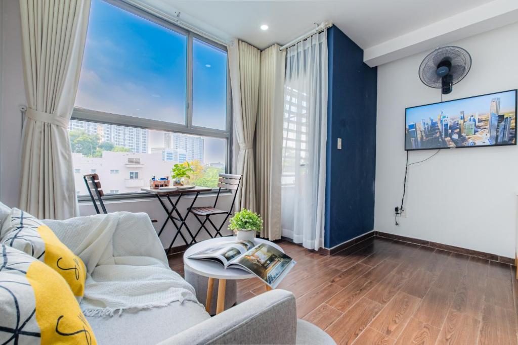 a living room with a couch and a large window at Orchard Garden -Near TSN Airport 5 minutes -Nice in Ho Chi Minh City