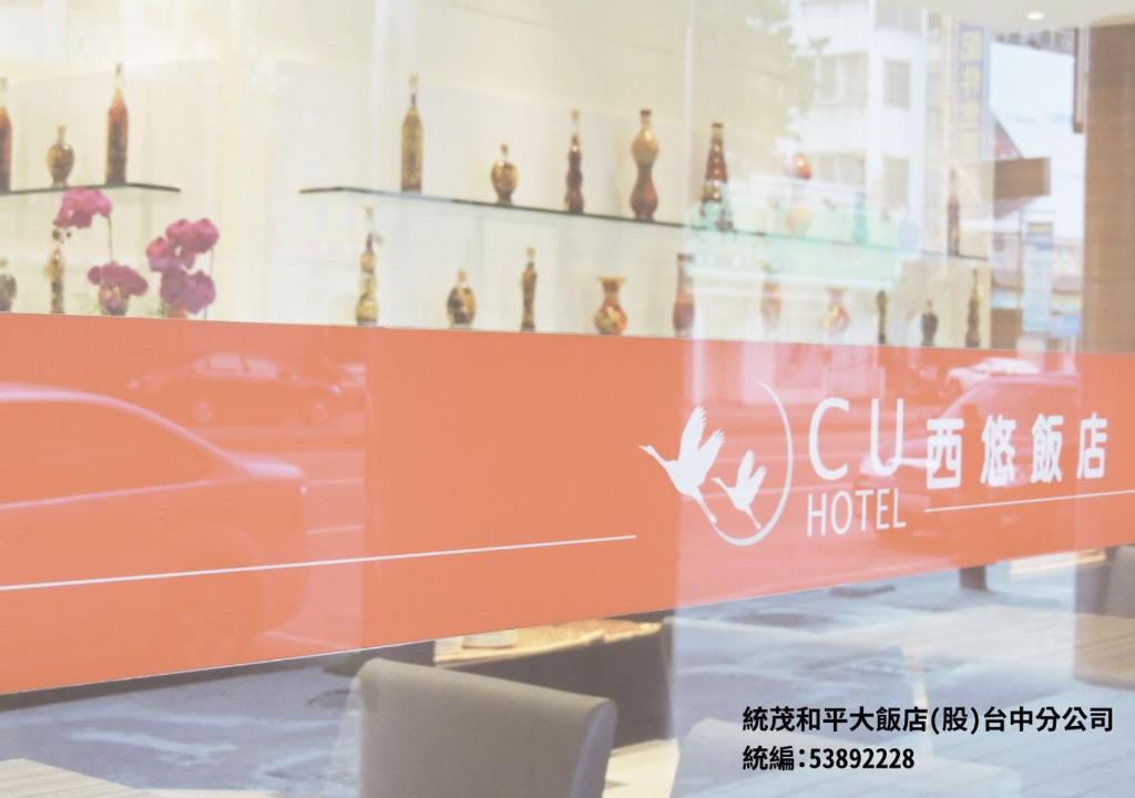 C U Hotel Taichung في تايتشونغ: نافذة فندق مع كرسي في الغرفة