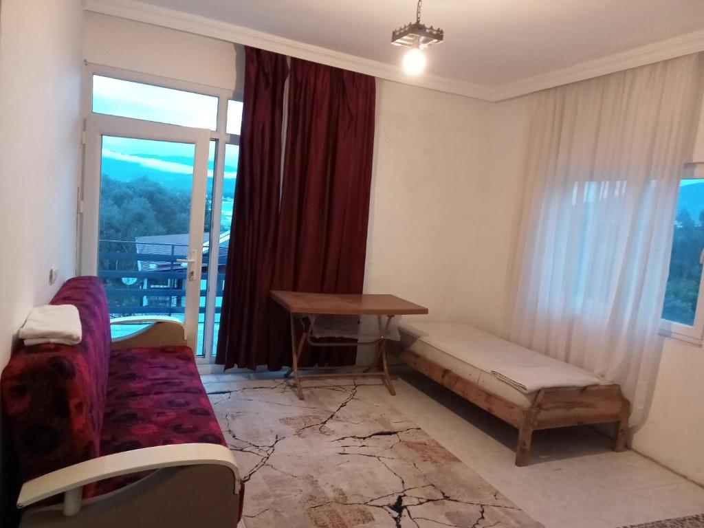 Zimmer mit einer Bank, einem Tisch und einem Fenster in der Unterkunft Modestus pansiyon otel in Uşak