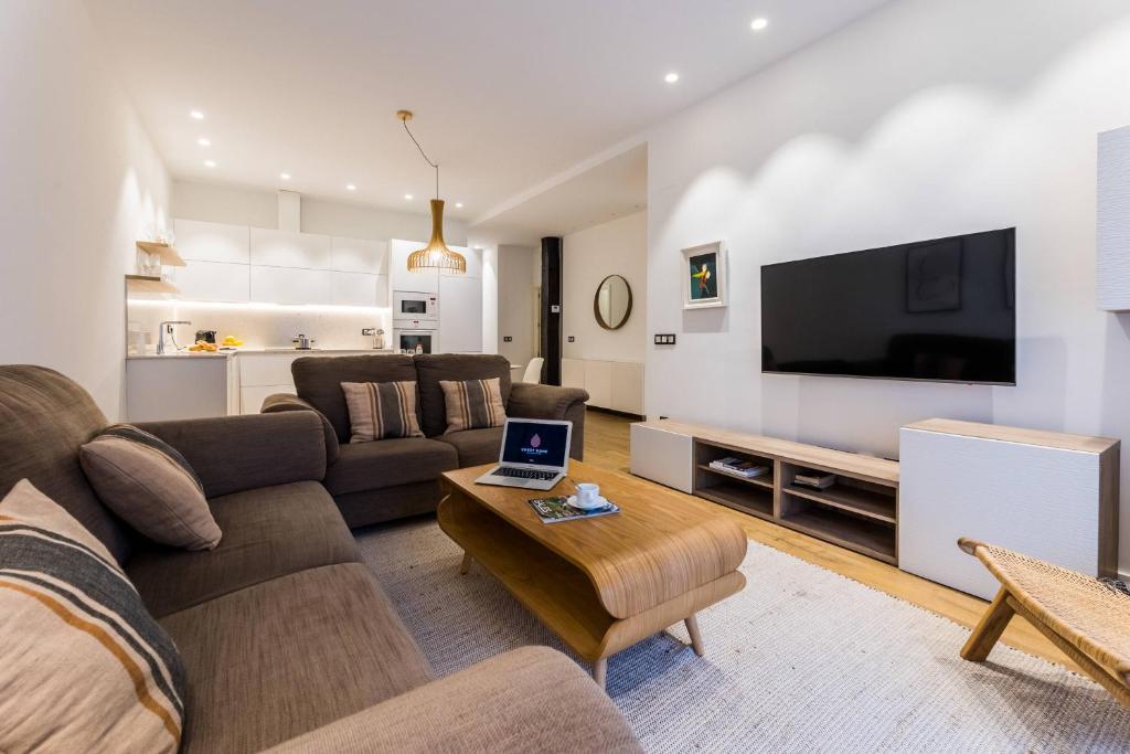 sala de estar con sofá y TV en BOULEVARD SUITE APARTMENT, en San Sebastián