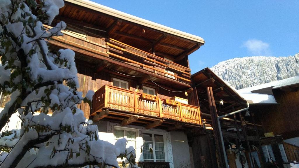 Cabaña de madera con balcón en la nieve en Apartments Cableway Canazei, en Canazei