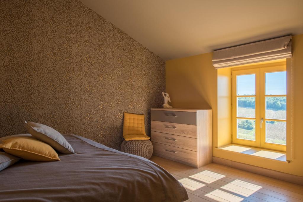 a bedroom with a bed and a window and a dresser at Chez Joseph - Au coeur des vignes de Saint-Romain in Saint-Romain