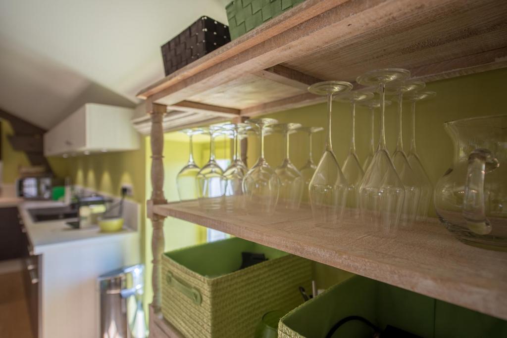 a row of glasses on a shelf in a kitchen at Chez Joseph - Au coeur des vignes de Saint-Romain in Saint-Romain