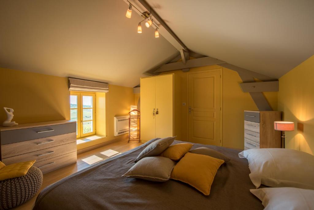 a bedroom with a large bed with yellow walls at Chez Joseph - Au coeur des vignes de Saint-Romain in Saint-Romain