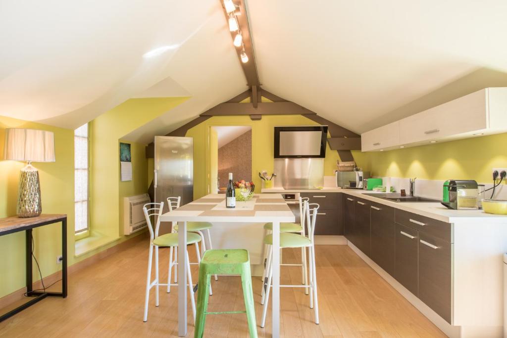 una cucina con un tavolo e sedie in una stanza di Chez Joseph - Au coeur des vignes de Saint-Romain a Saint-Romain