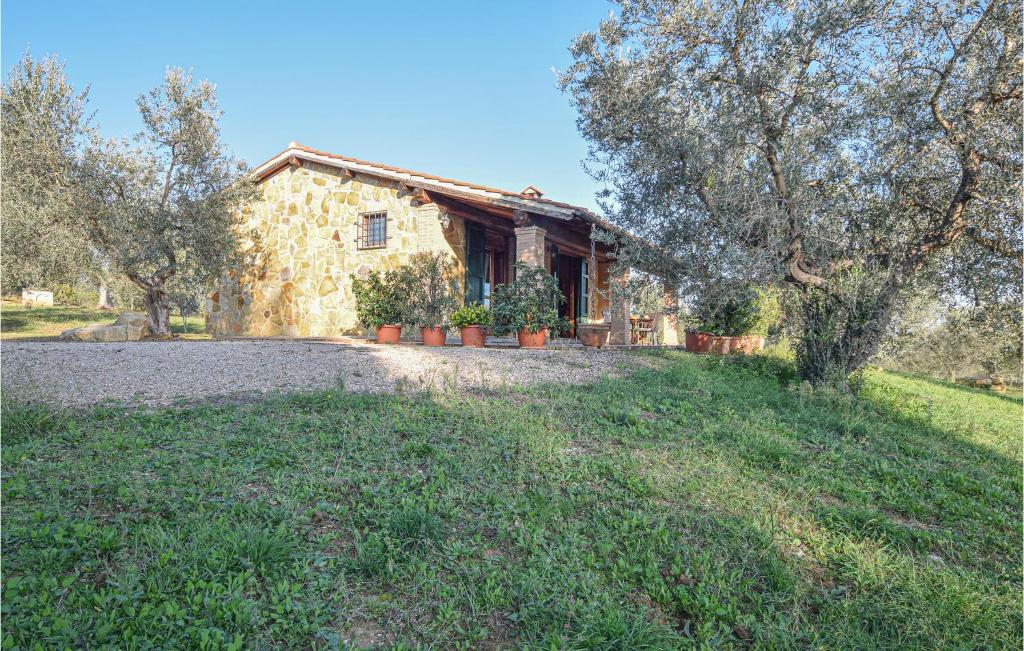 a stone house with a yard in front of it at Casa Giannini in Magliano in Toscana