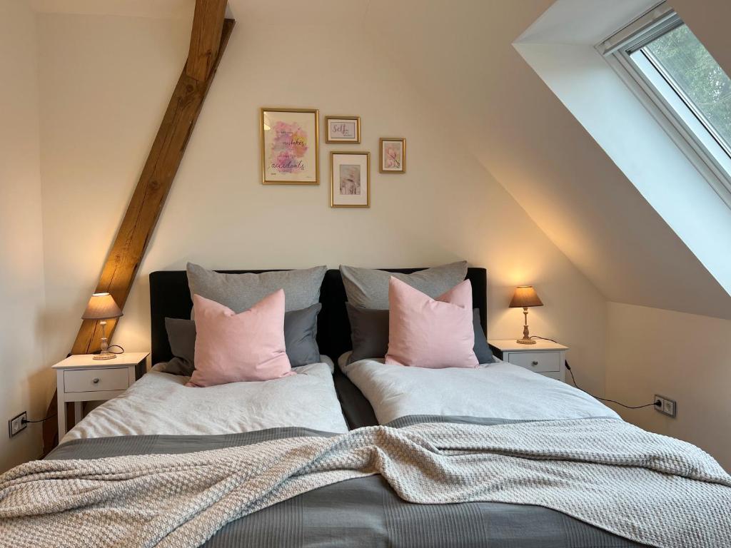a bedroom with two beds with pink pillows at INTERGO Apartments in Brackel