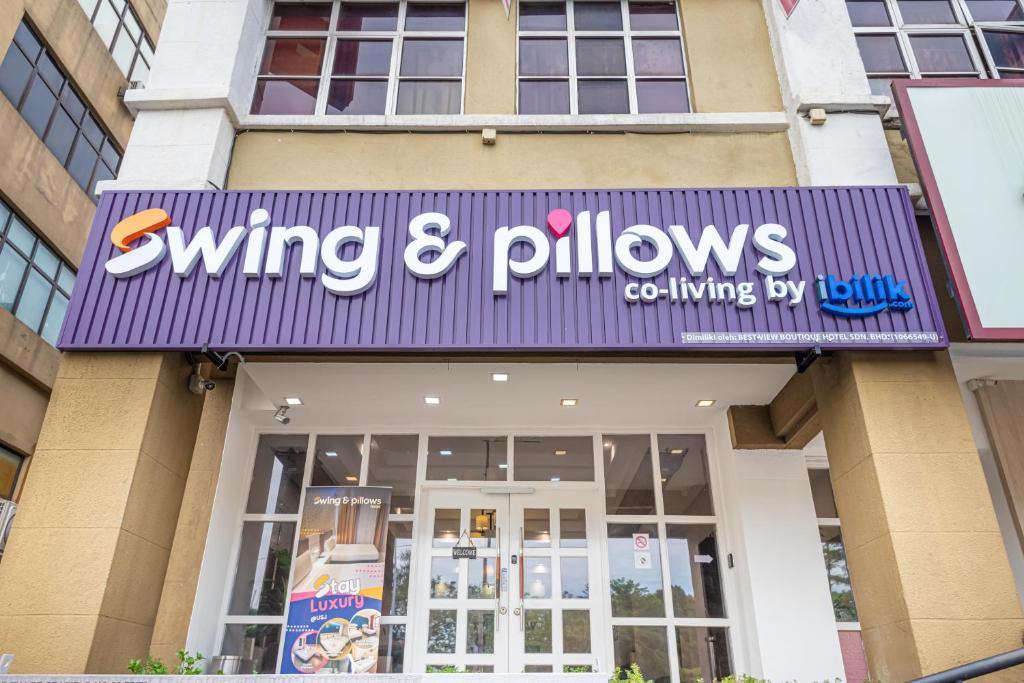 een bord met winnende en kussens aan de zijkant van een gebouw bij Swing & Pillows - USJ Taipan in Subang Jaya
