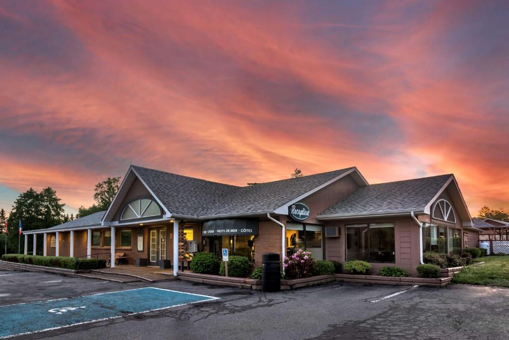 ein Gebäude mit wolkigem Himmel darüber in der Unterkunft Dannys Hotel Suites; SureStay Collection by Best Western in Beresford