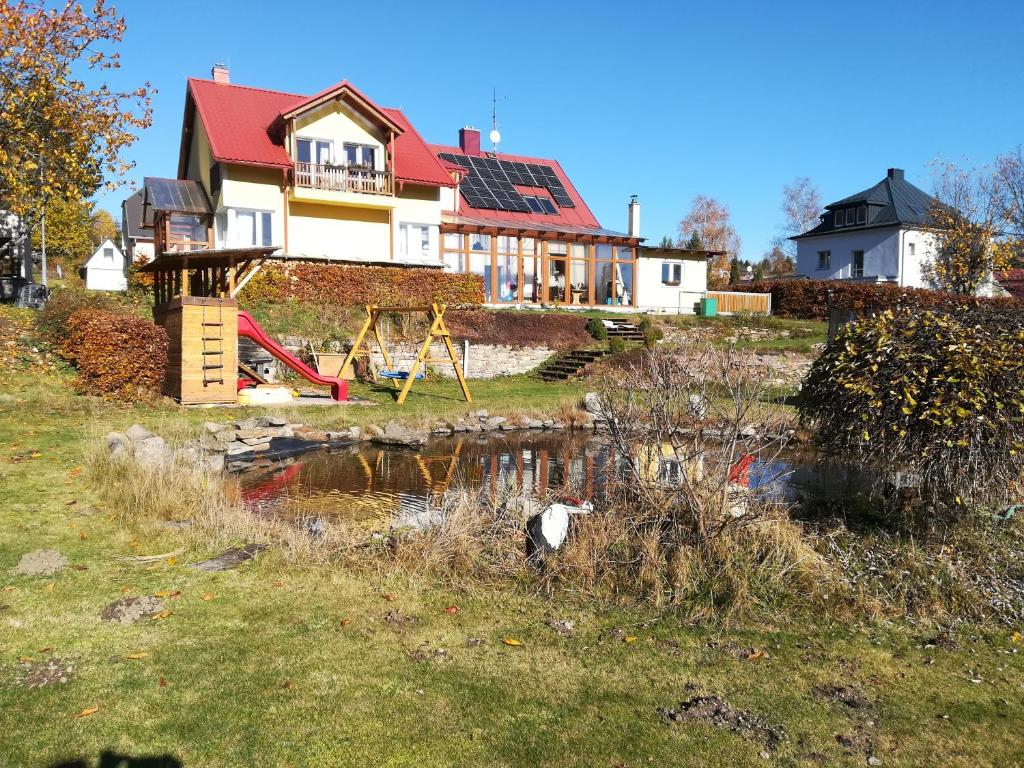 ein Haus mit einem Teich davor in der Unterkunft Apartments Pernink 341 in Pernink