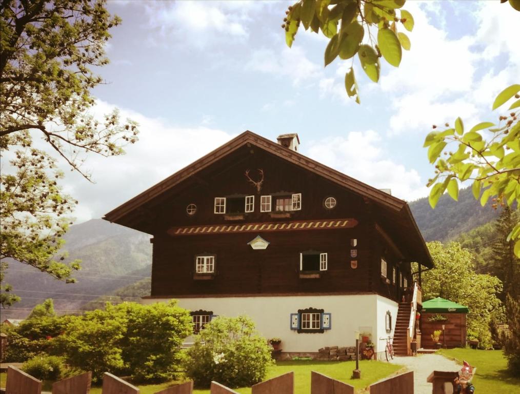 una casa en blanco y negro con montañas al fondo en Ferienlounge Bluntausee en Golling an der Salzach